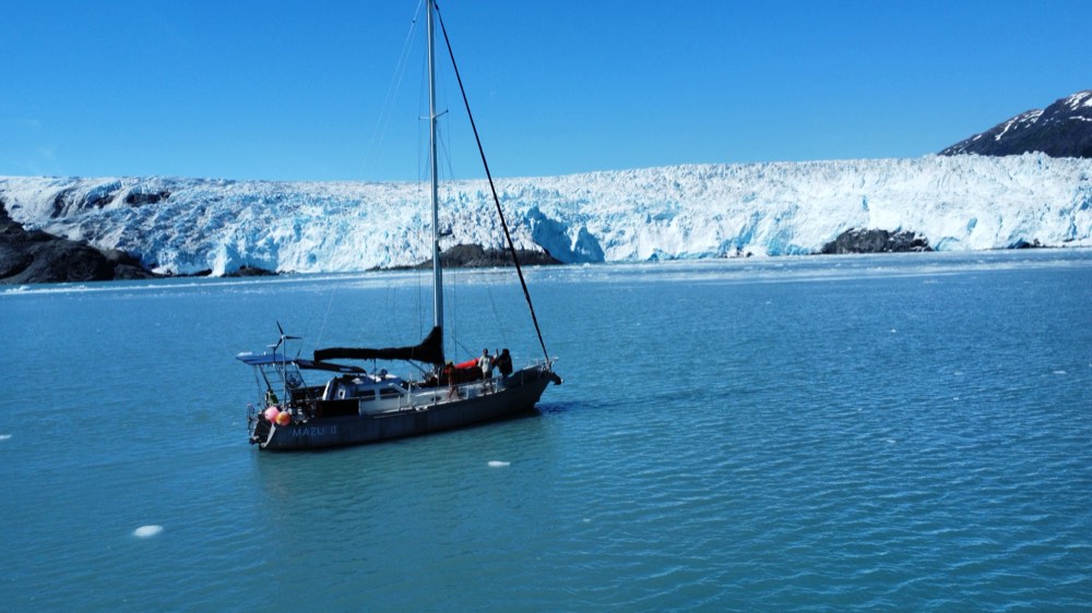 Mazu II at anchor with Alaskan mountains behind