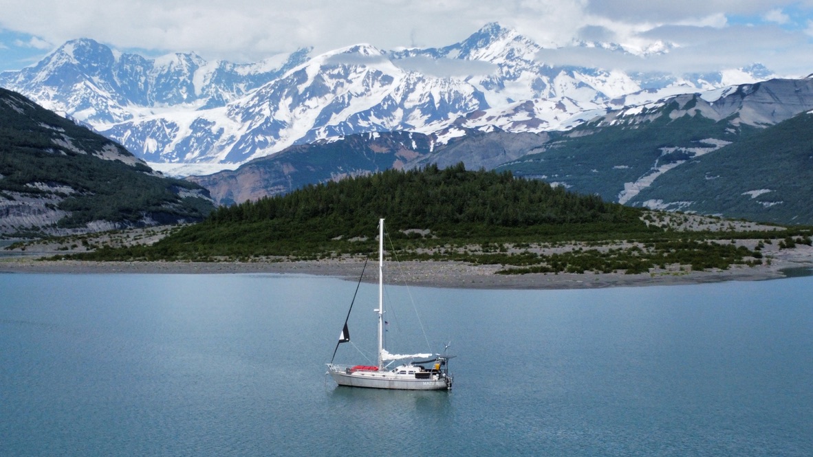 Mazu II at anchor beneath snow-capped Alaskan peaks