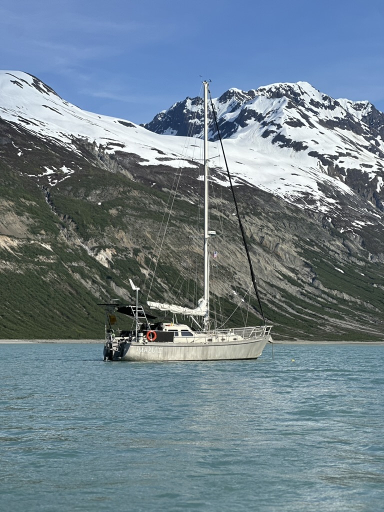 Mazu II at anchor beneath snowy Alaskan peaks